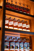 Shelves displaying multiple bottles of Savor Speer brand on a wooden shelf.