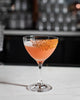 Cocktail in a glass with a textured rim on a bar counter