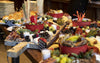 Assorted food platter with fruits, vegetables, and dips on a wooden board.