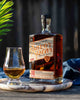 Bottle of Savor Spear whiskey with a glass on a wooden surface