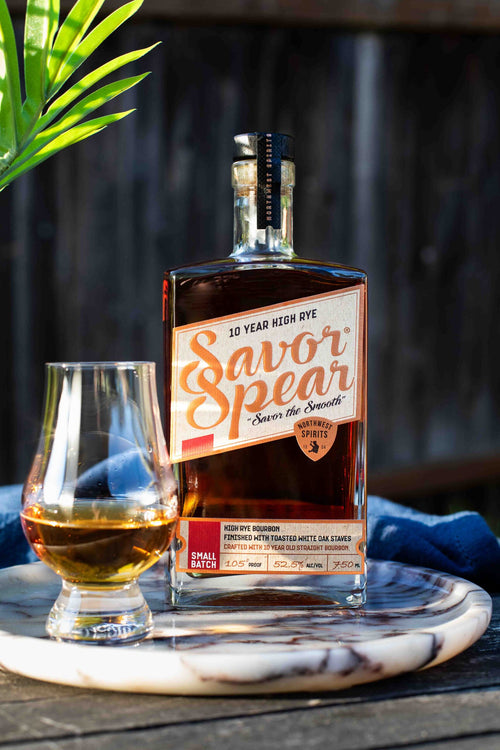 Savor Spear whiskey bottle with a glass of whiskey on a marble coaster