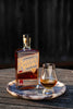Bottle of Savor Spear whiskey with a glass on a wooden surface